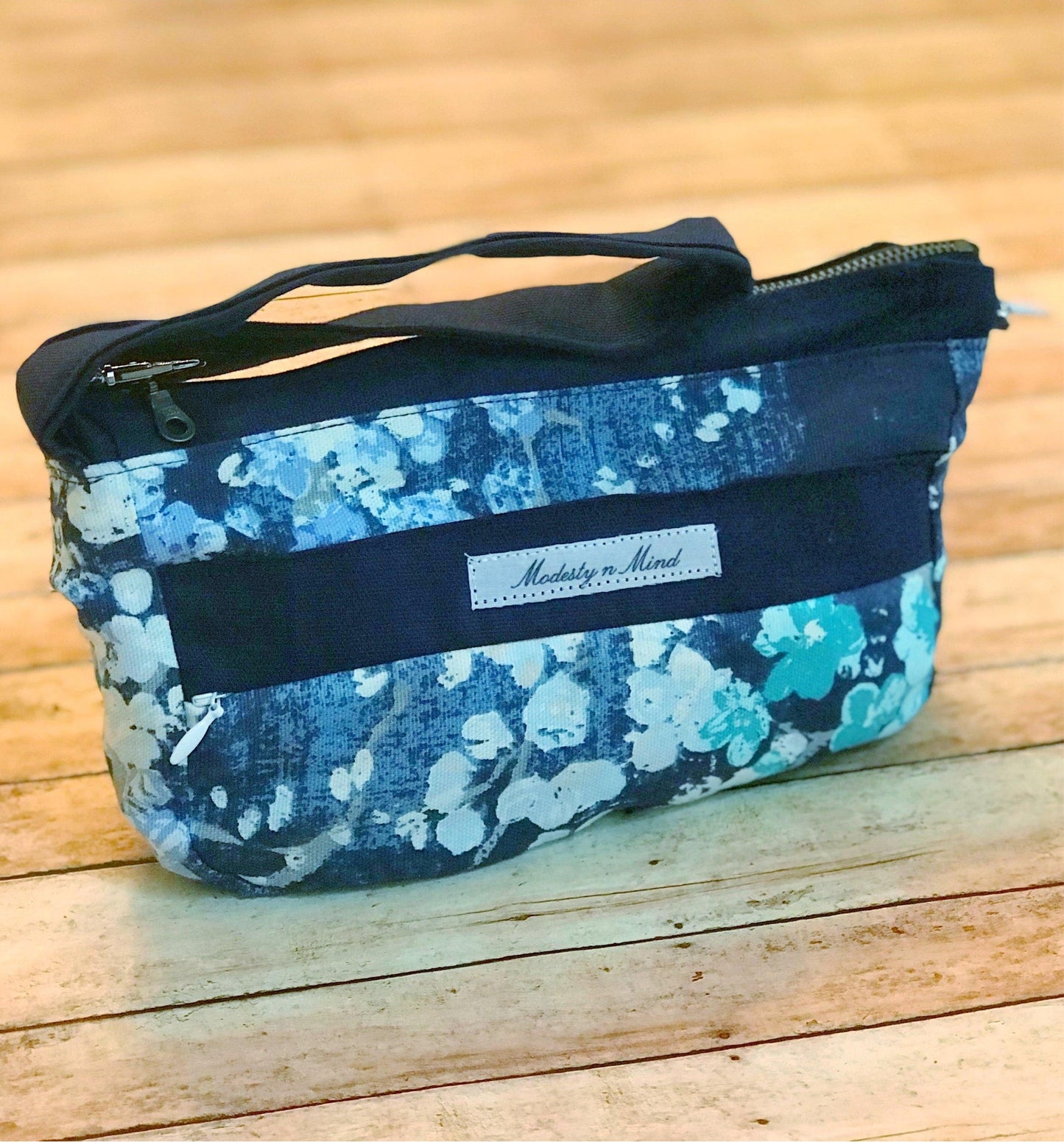 blue teal floral wristlet sitting on a backdrop