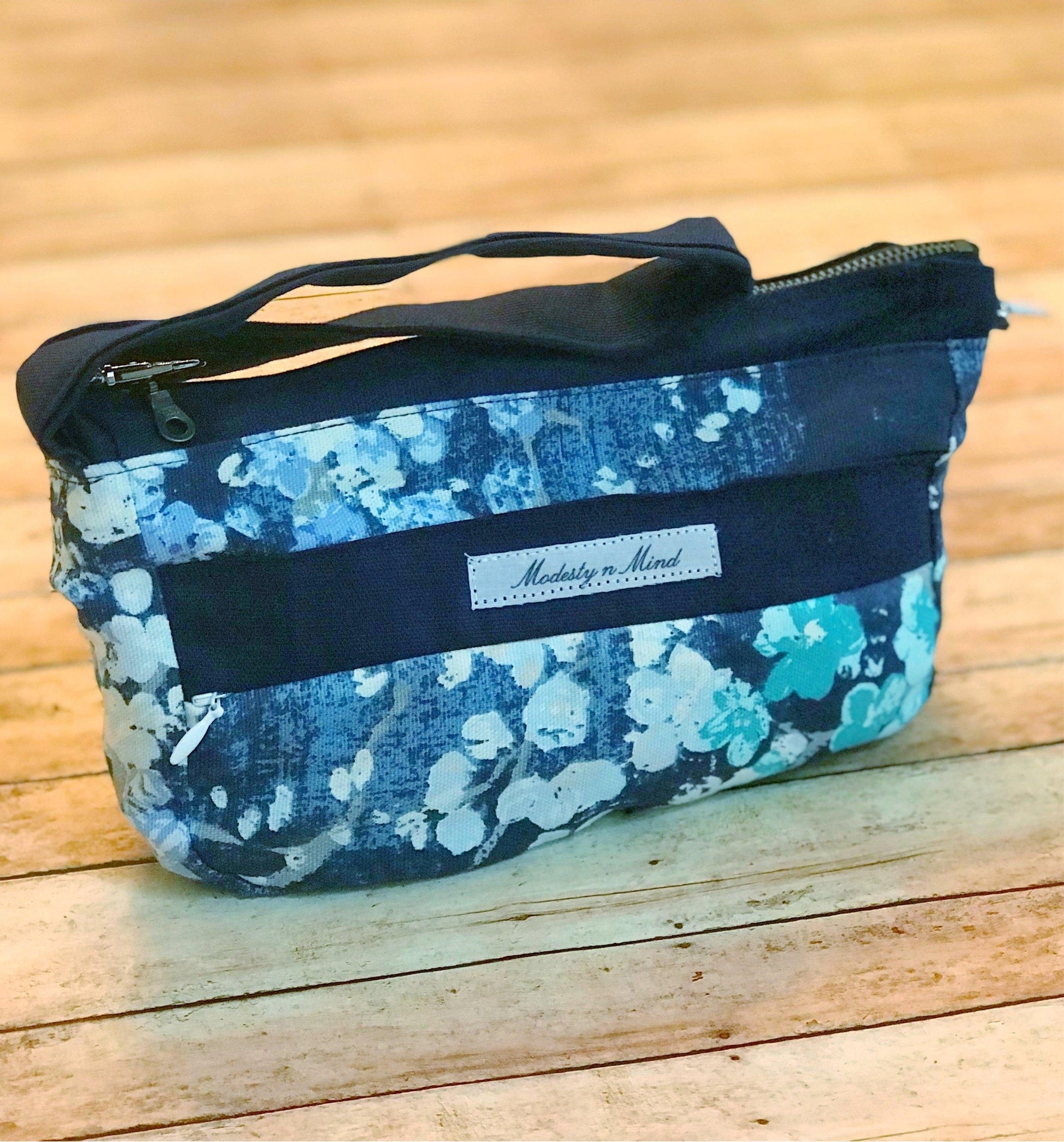 blue teal floral wristlet sitting on a backdrop