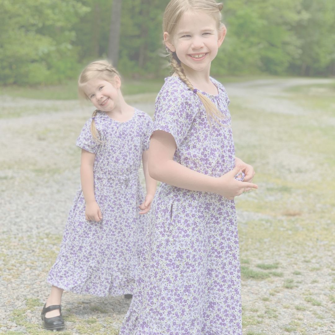2 Girls modeling purple floral dresses