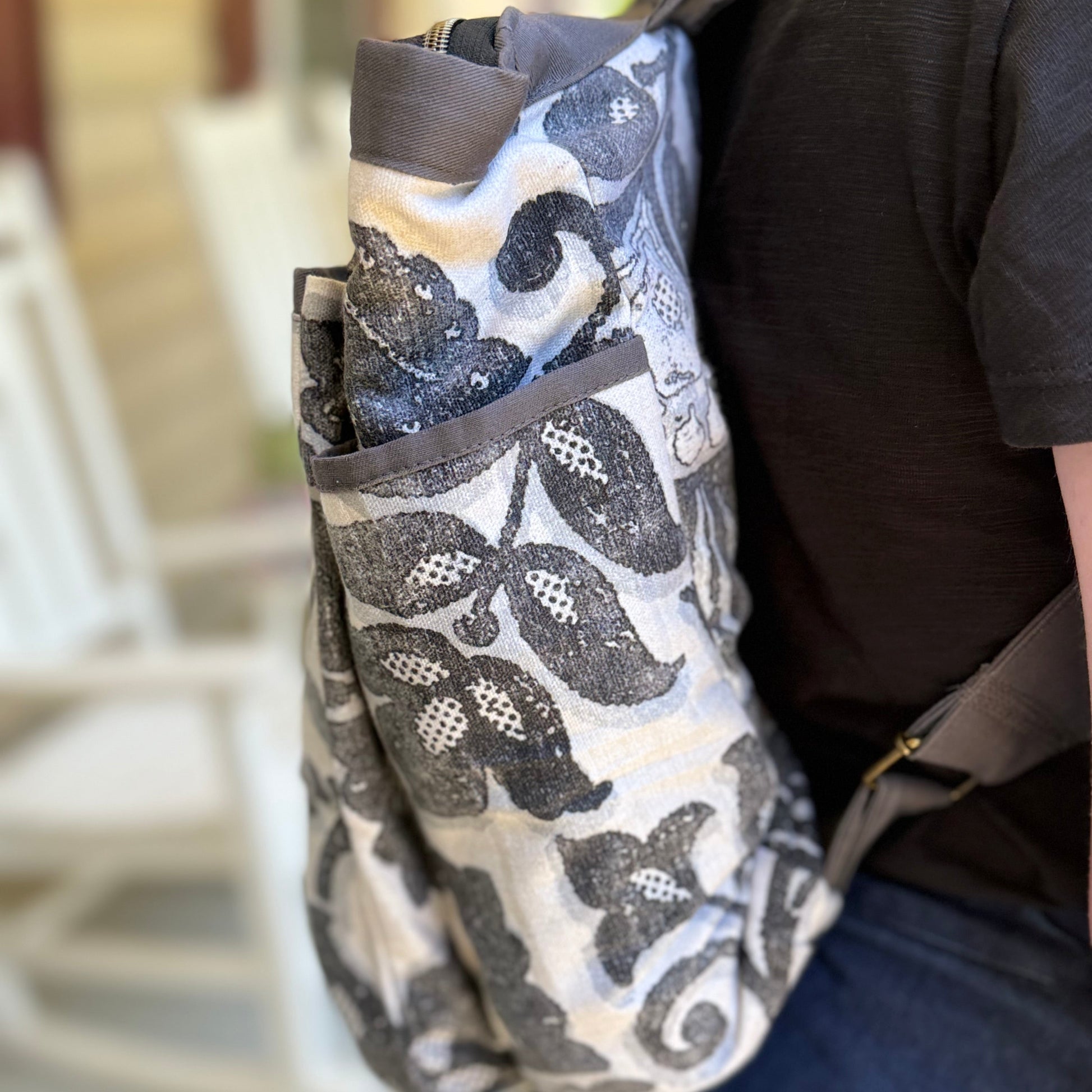 Person wearing a patterned bag over their shoulder outdoors