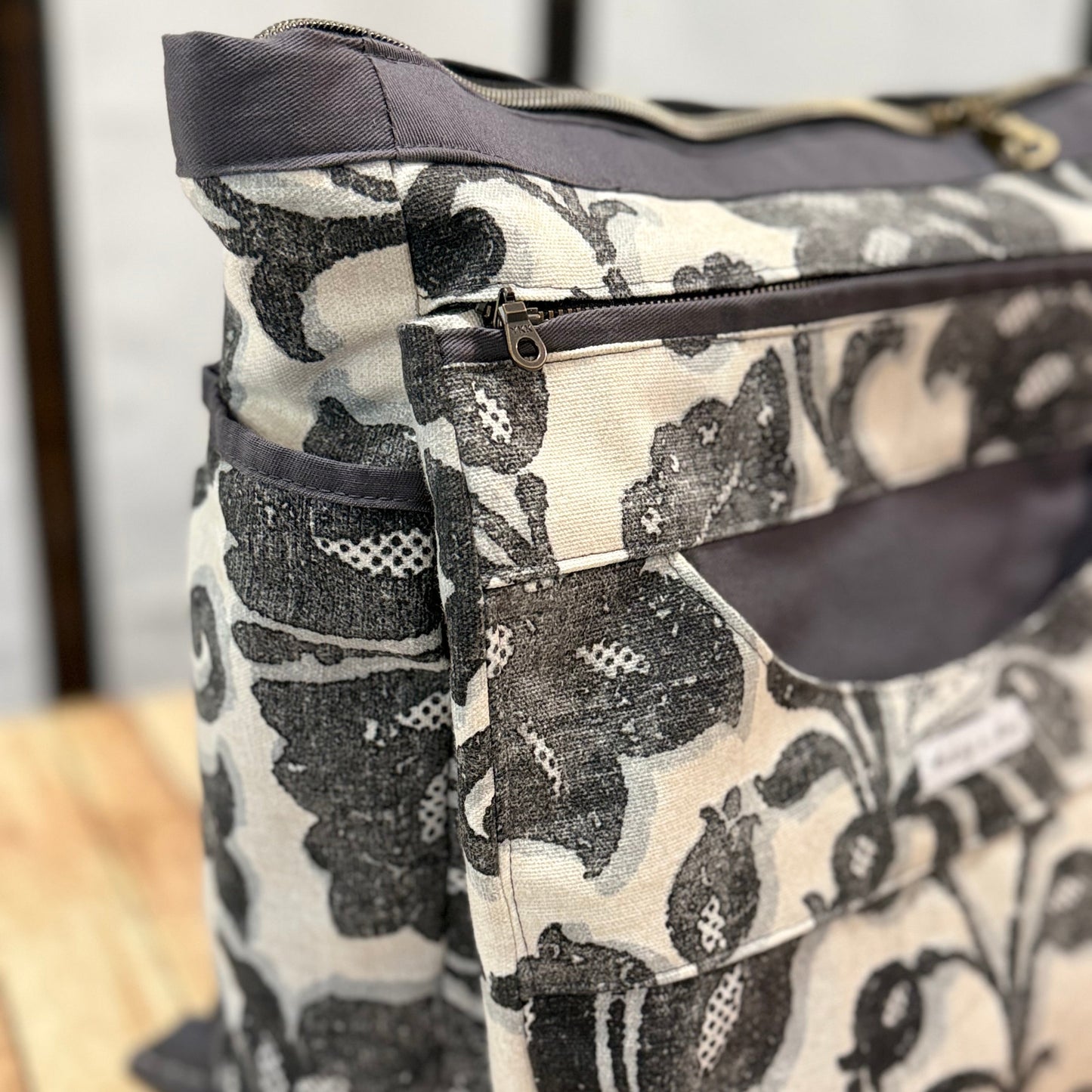 Floral patterned bag with gray accents on a wooden surface