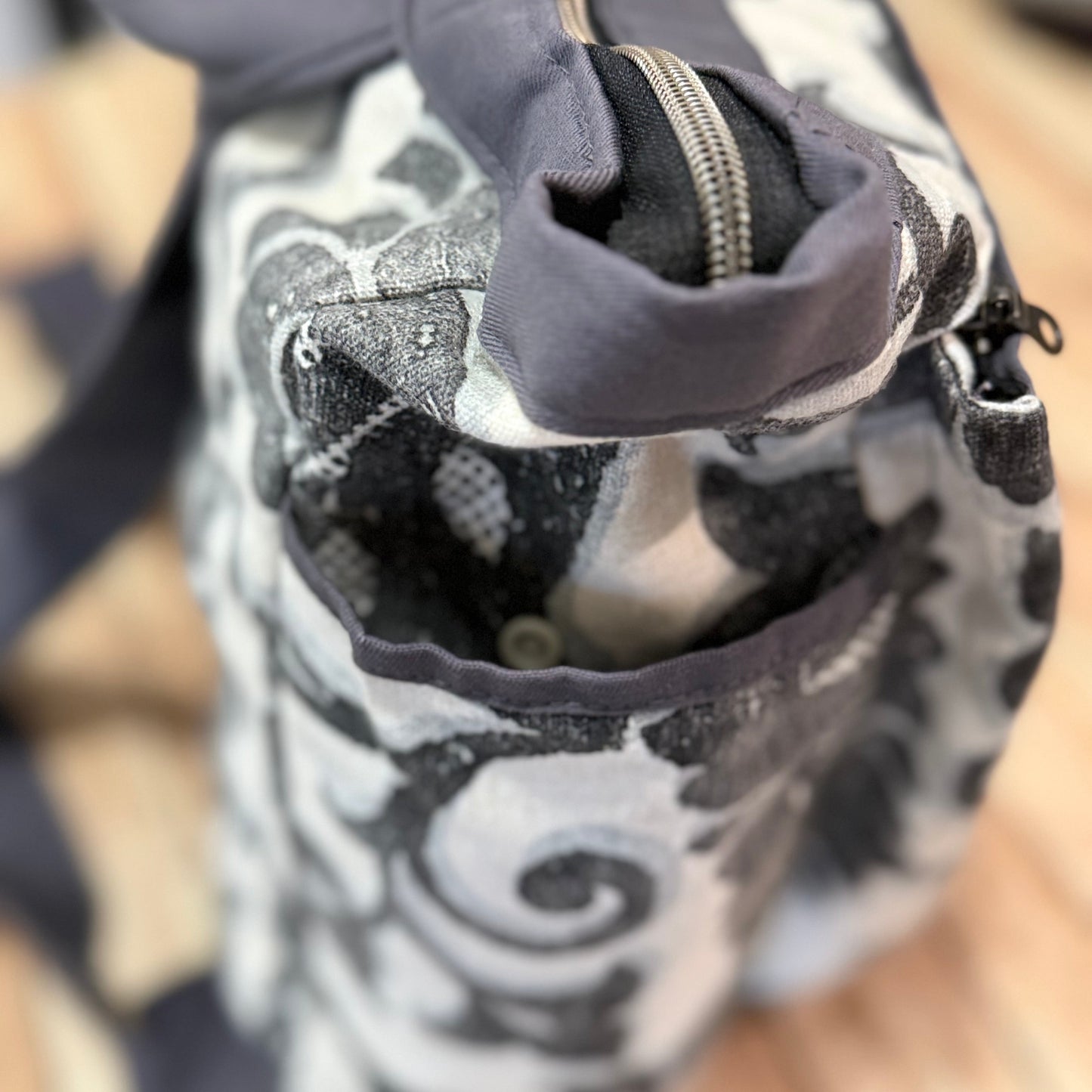 Close-up of a patterned bag with a zipper on a blurred background
